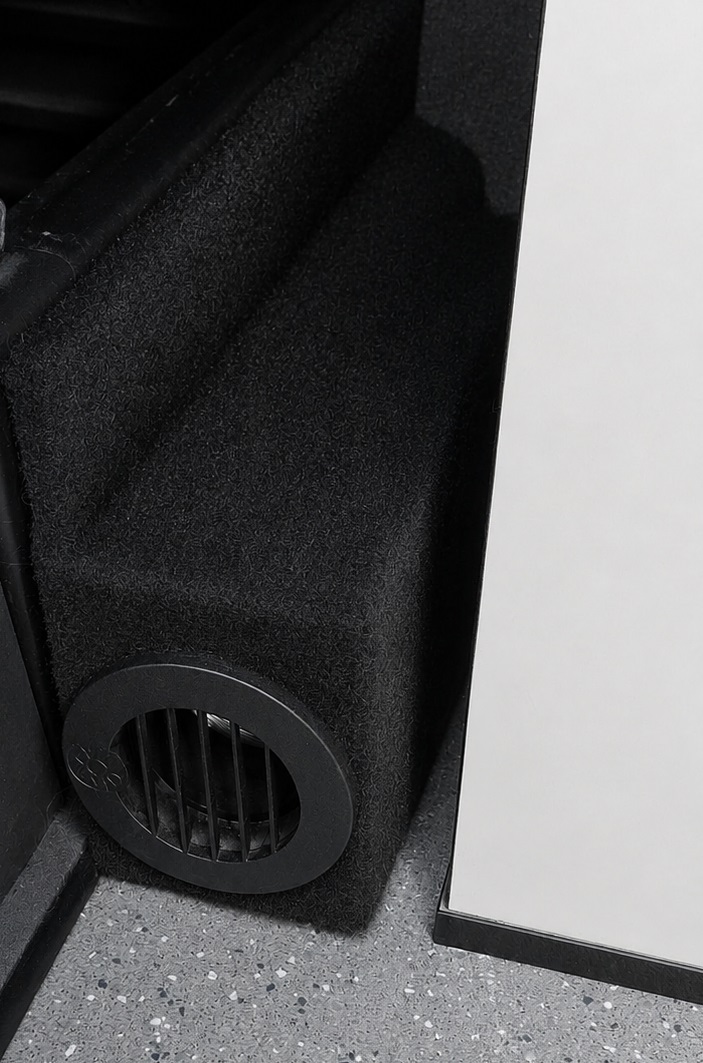 Diesel heater outlet vent fitted into carpet-lined campervan furniture