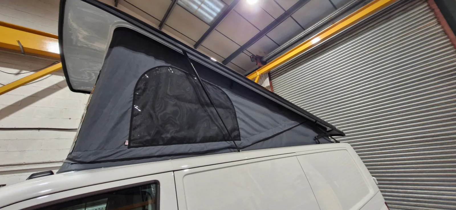Side view of the Storm LWB pop-top raised on a white VW T6.1, showing grey scenic canvas with a mesh window