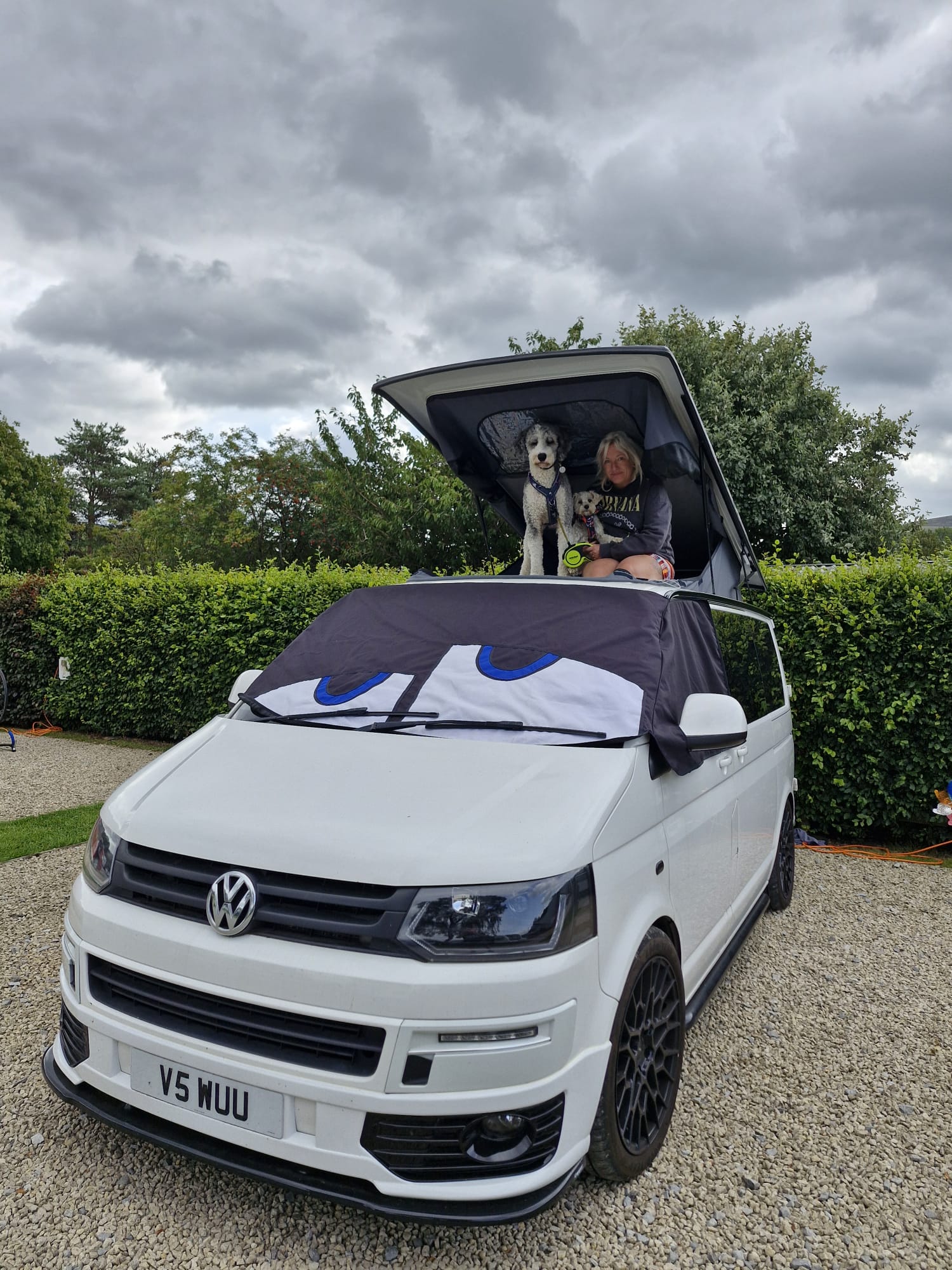 Storm pop-top roof raised on a white VW Transporter, with the upper bed area in use