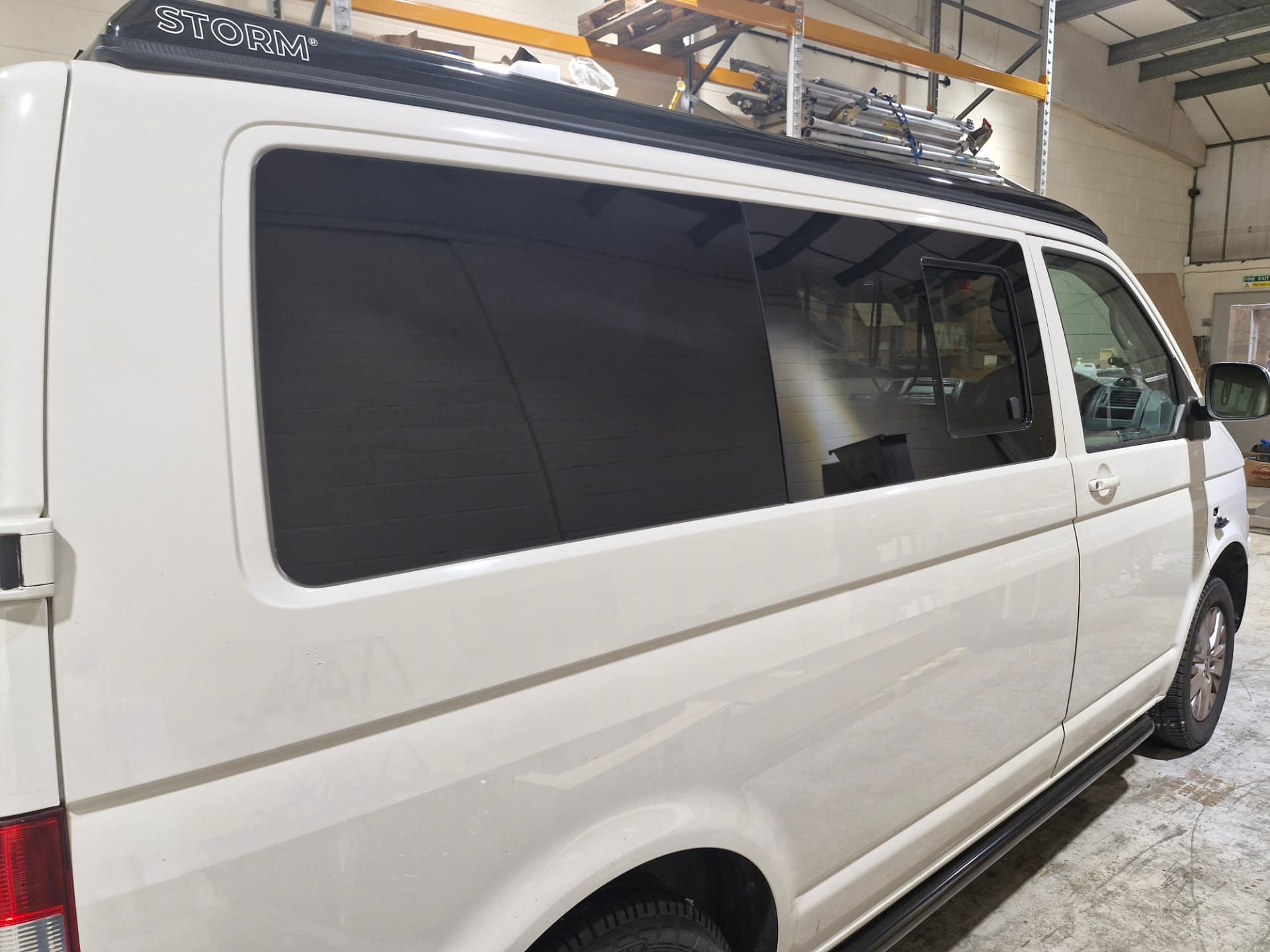 Finished bonded privacy window fitted to the side of a white VW Transporter